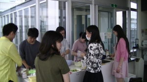 留学生がベトナムの定番料理を英語で紹介し、文化交流をしている様子