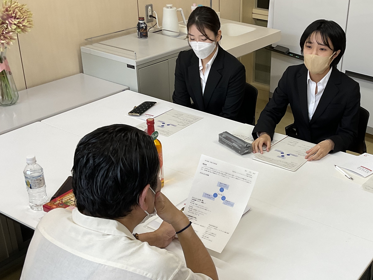 産学連携先の社長にプレゼンする学生